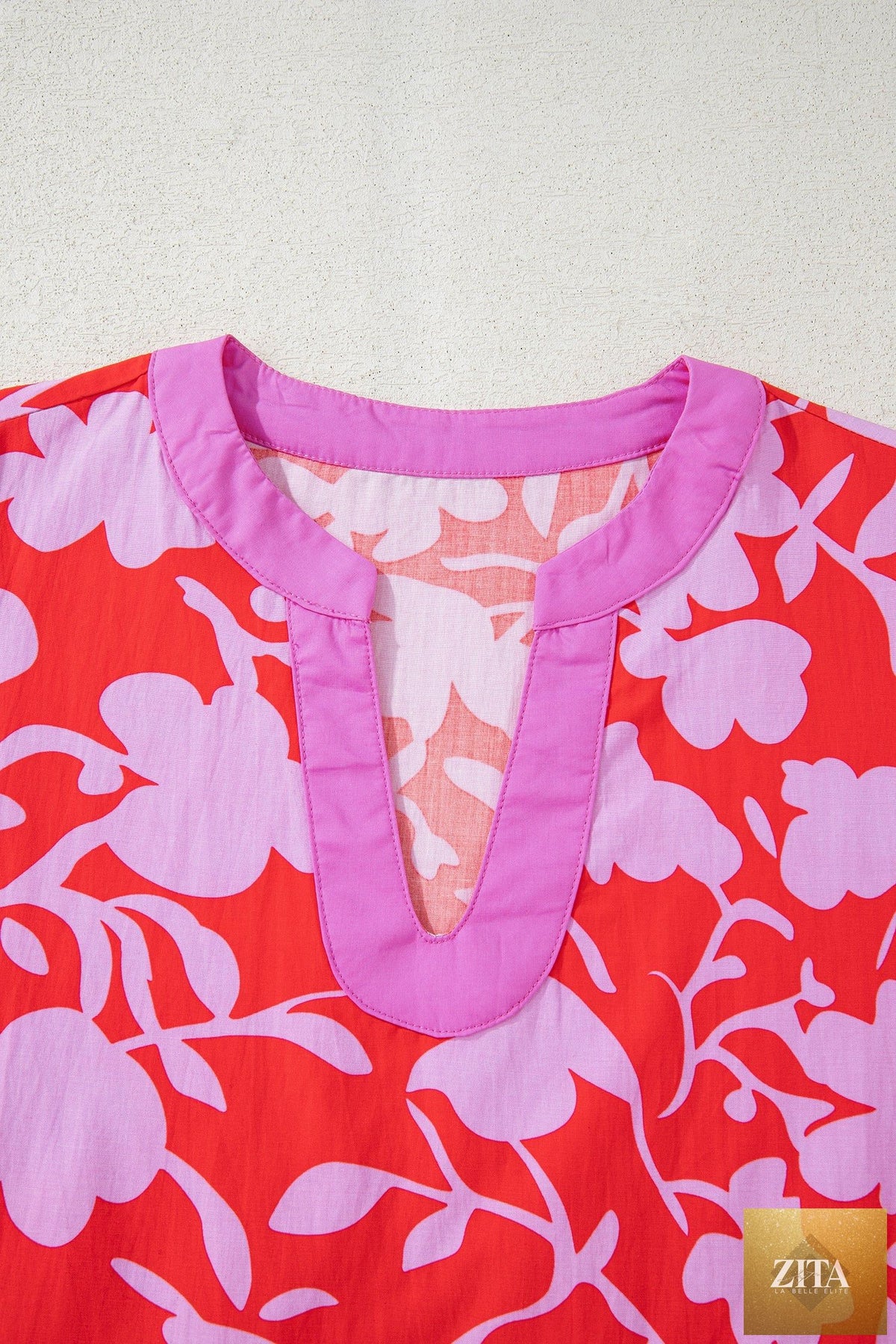 Red floral print blouse with split V-neck, cuffed bracelet sleeves, and relaxed fit, from Wild and Free Boutique.
