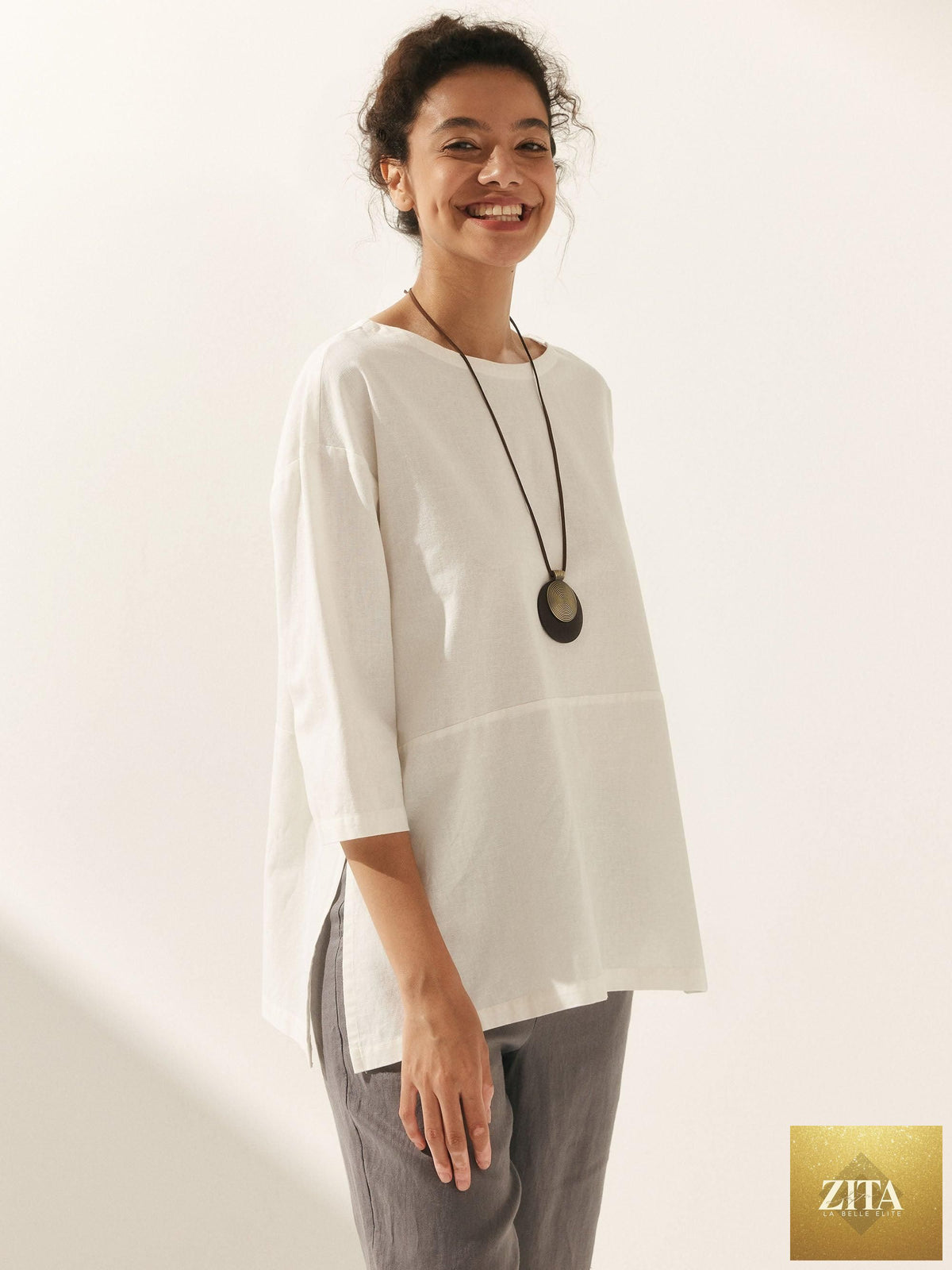 LINTICO linen white boat neck oversized top, blouse style with relaxed fit, made from linen blend fabric, displayed on hanger.