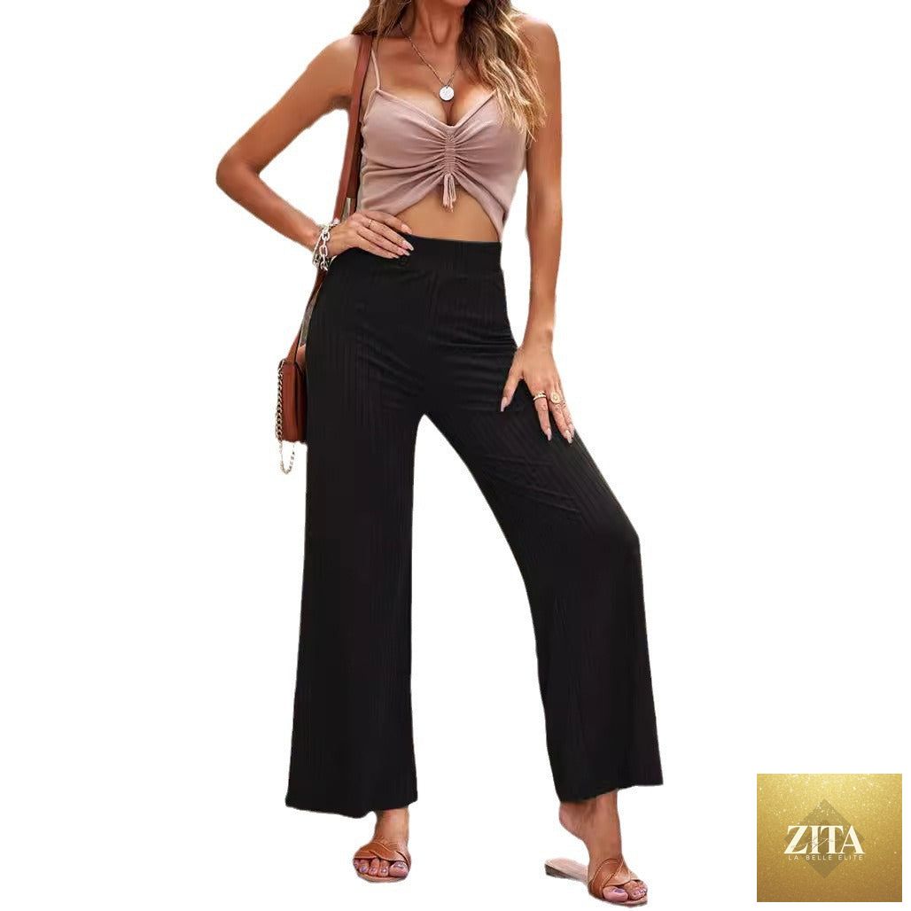 Women's high-waisted ribbed straight-leg pants in a neutral color, showcasing the fitted waistband and relaxed leg fit.