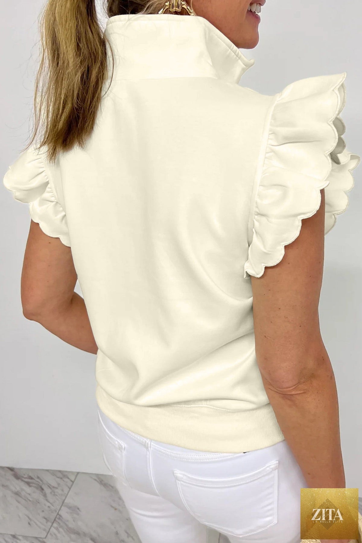 Beige zipped collared ruffled short sleeve blouse from Wild and Free Boutique, featuring a stylish design and feminine details.