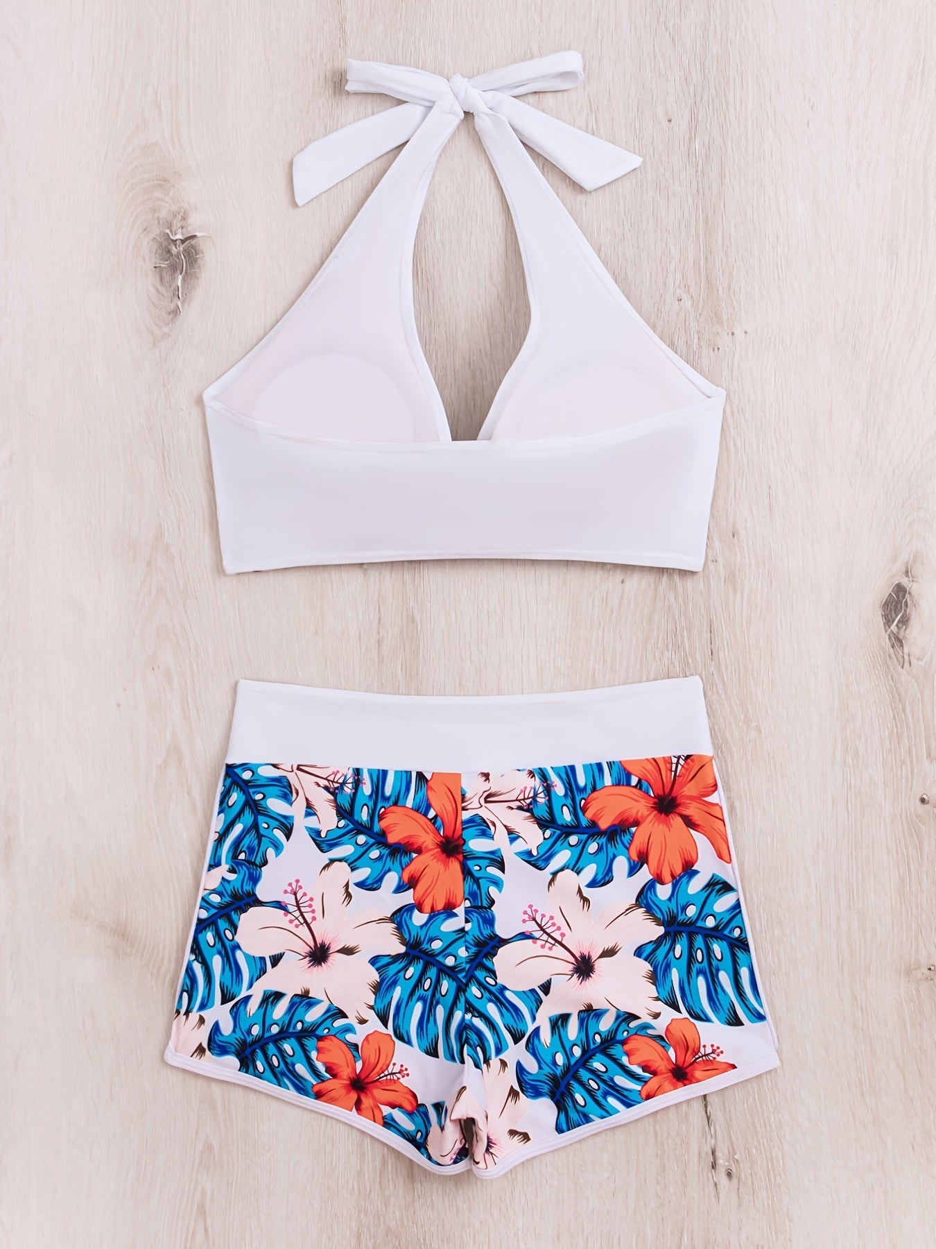 Stevvex floral halter neck bikini set with backless design, tie-neck bow, high waist shorts, perfect for summer beach and pool days.