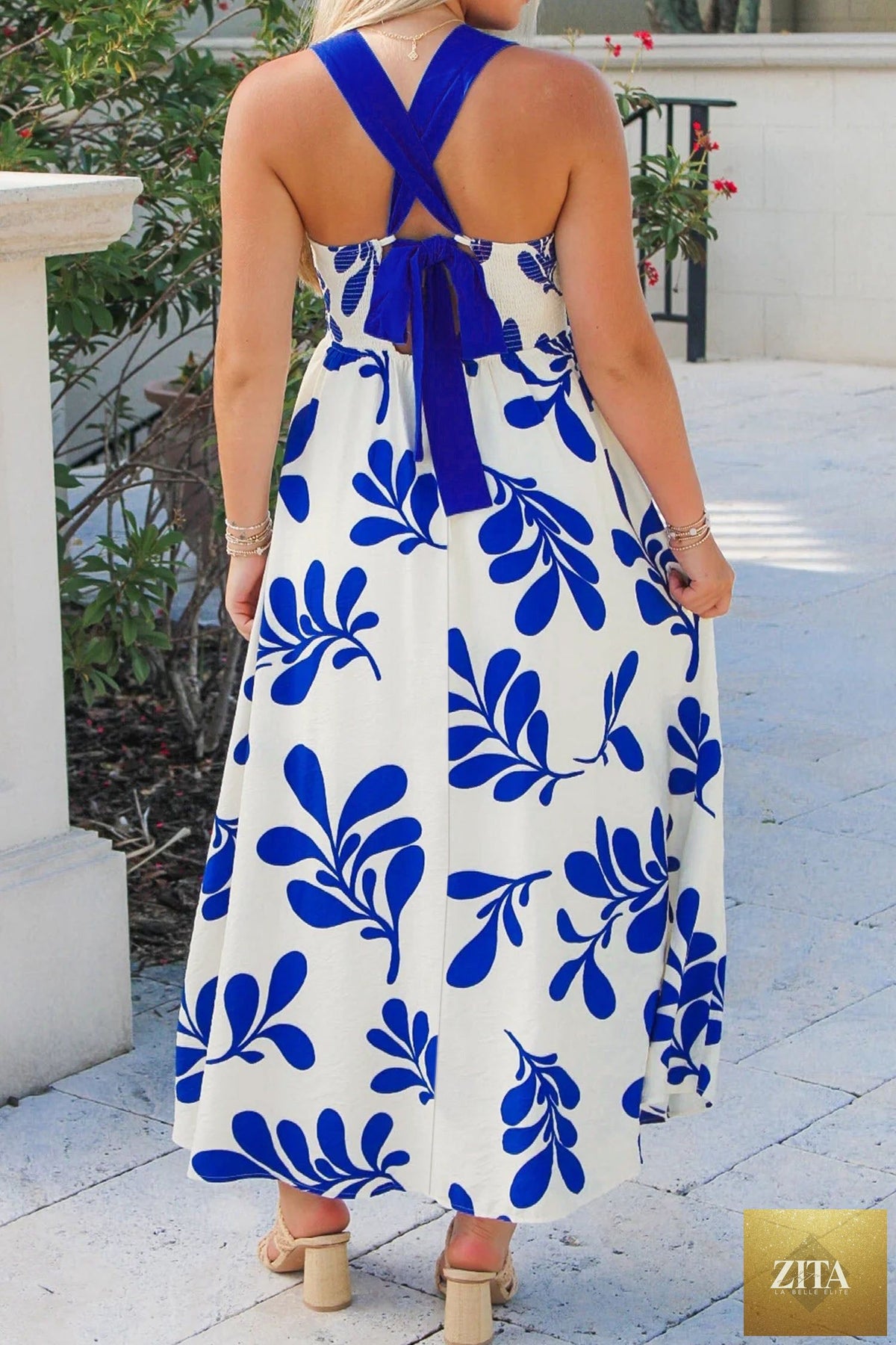 Blue floral print maxi dress with crisscross tie back and sleeveless design by Wild and Free Boutique.