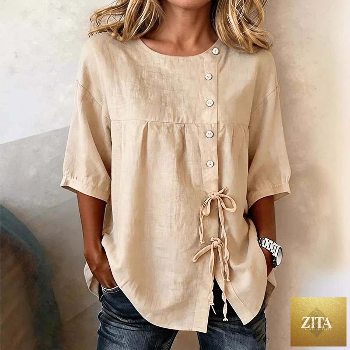 Women's linen lace-up button shirt with 3/4 sleeves and asymmetric hem, by Zita La Belle Elite, shown on a hanger.