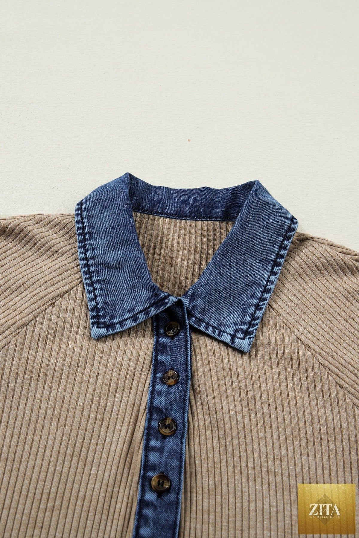 Beige ribbed knit long sleeve polo top with denim patchwork and button details, featuring a collar and cuffed sleeves.
