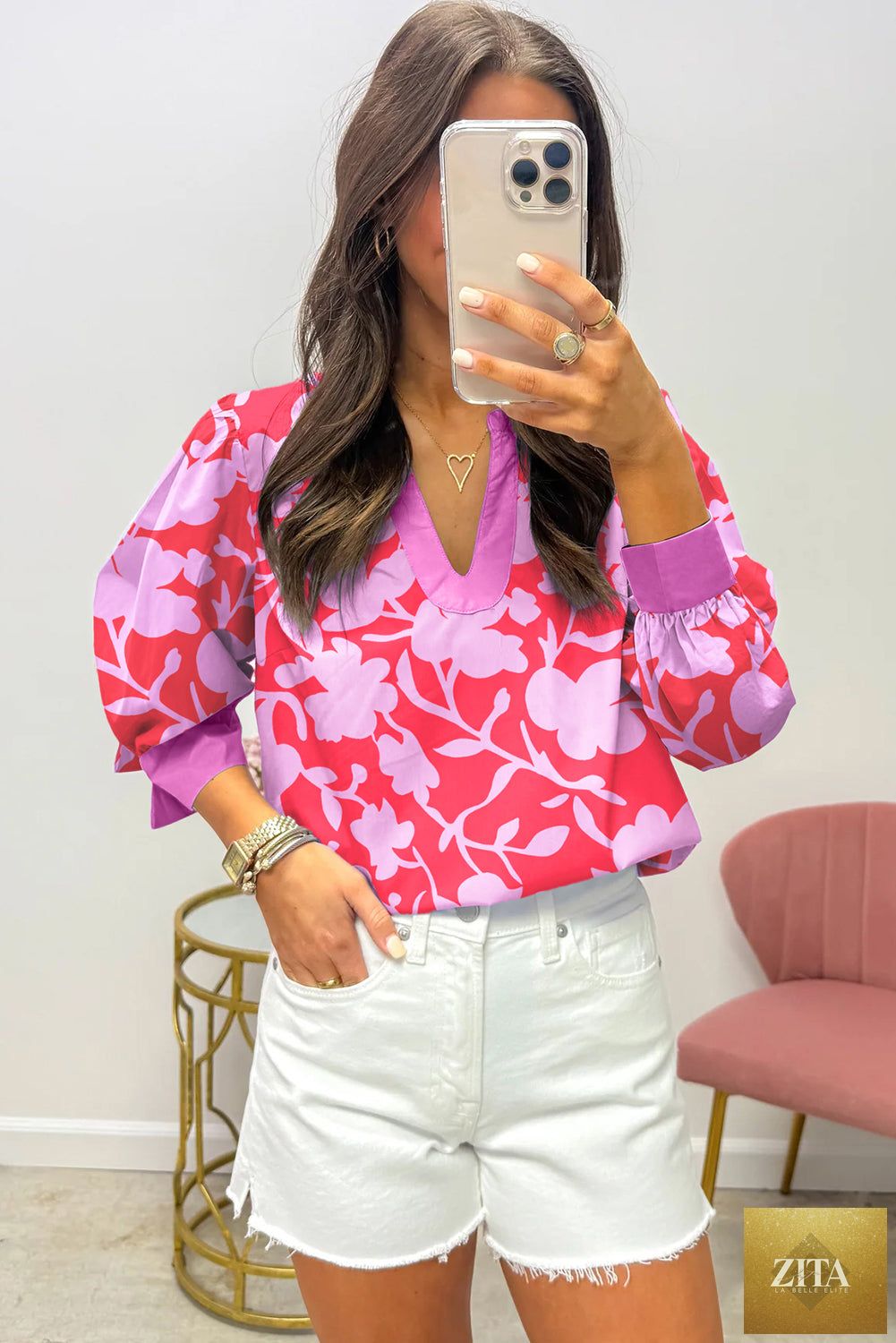Red floral print blouse with split V-neck, cuffed bracelet sleeves, from Wild and Free Boutique, shown on a hanger.