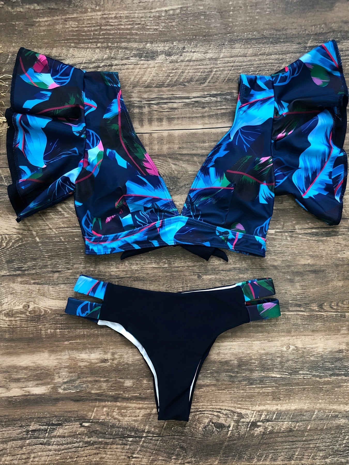 Stevvex Bloom Day Ruffle Bikini Set with plant print, V-neck, tie-back, and high-stretch ruffle trim for women’s poolside style.