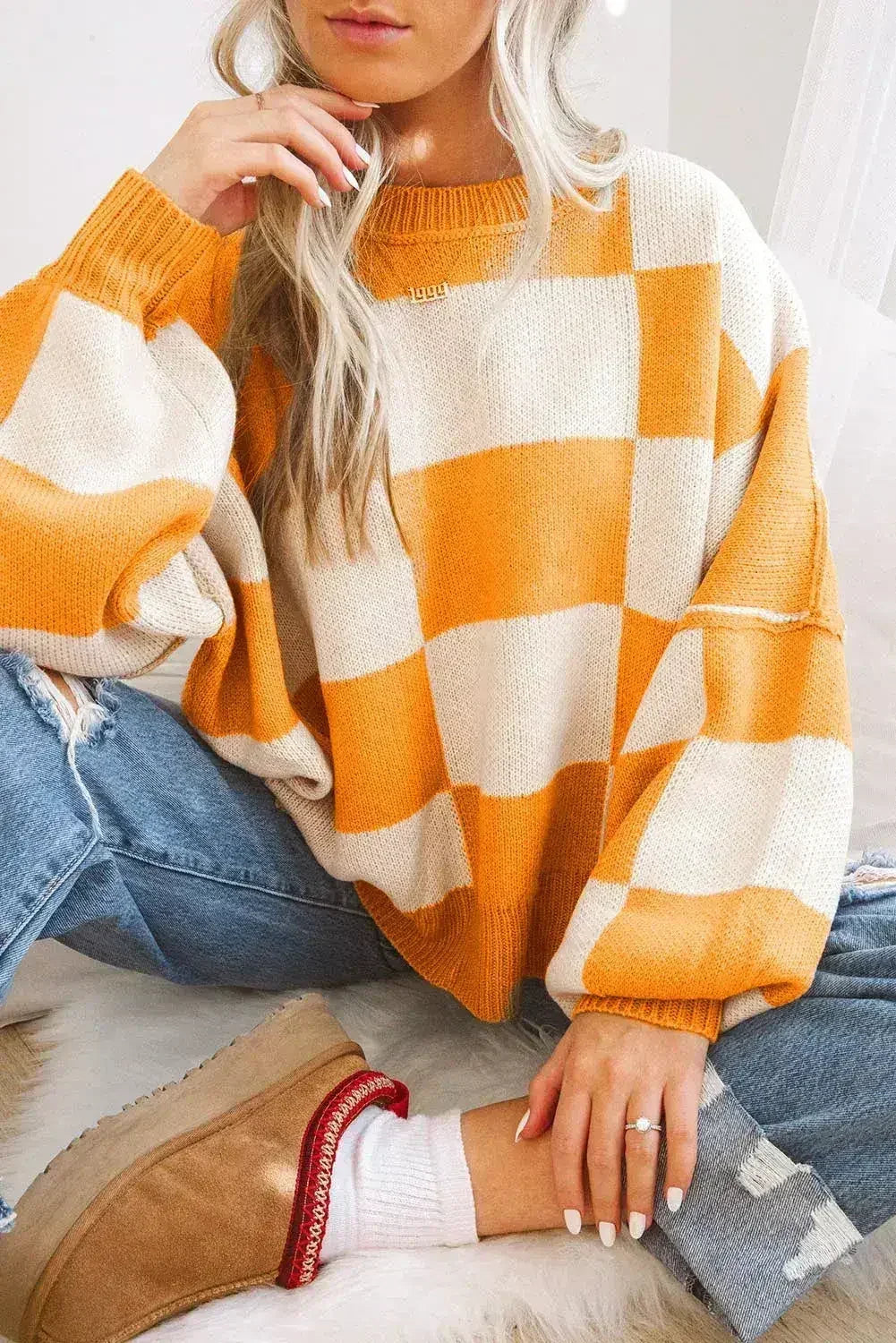 Orange checkered Femstylo bishop sleeve sweater with a cozy fit and stylish design, featuring a classic pattern and textured fabric.