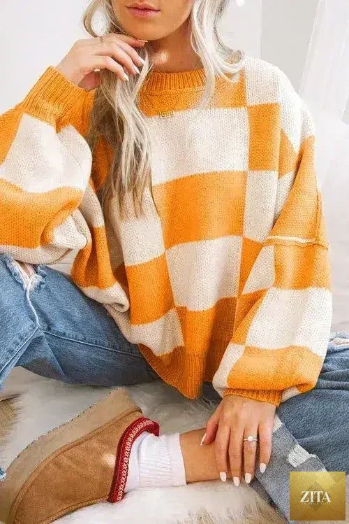 Orange checkered Femstylo sweater with bishop sleeves, featuring a cozy knit design and classic pattern, perfect for stylish winter wear.