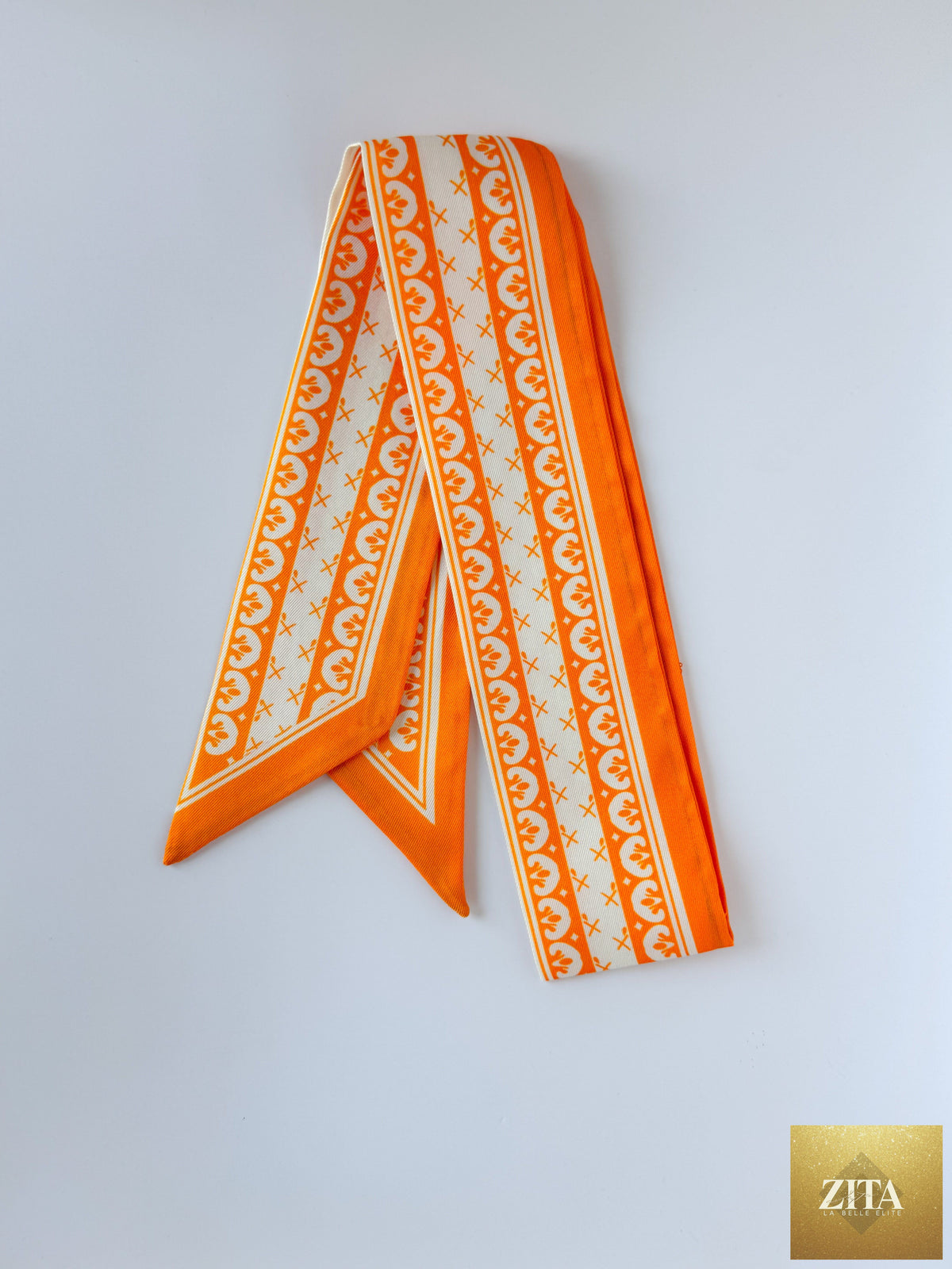 Orange and white Hibiscus Linens Twilly ribbon with a delicate floral pattern, perfect for accessorizing or gift wrapping.