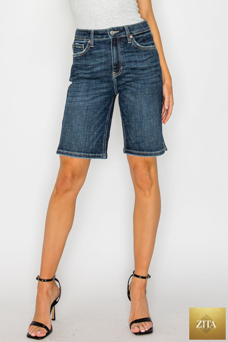 Artemis Vintage Celeste dark wash high rise Bermuda jeans displayed on a hanger with a folded cuff.