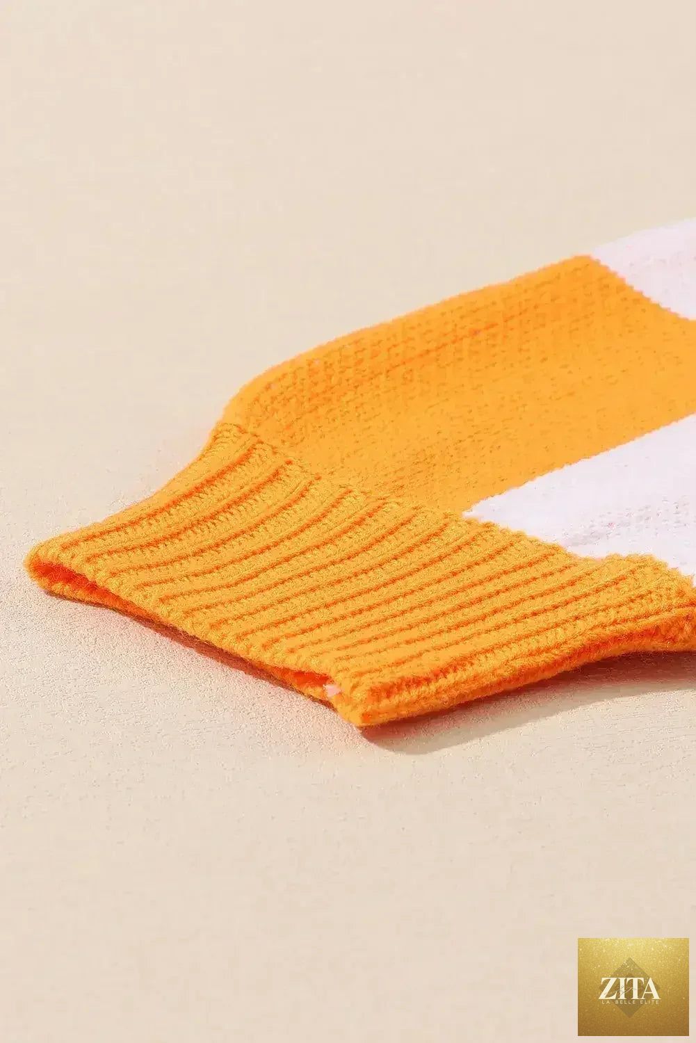 Orange checkered Femstylo bishop sleeve sweater with a cozy knit texture and stylish design.
