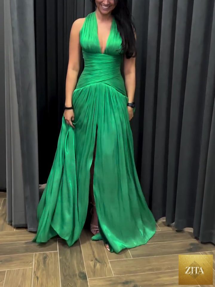 Emerald green plunging neckline gown with pleated skirt and side slit by The Fashion Celestial, shown on a model.