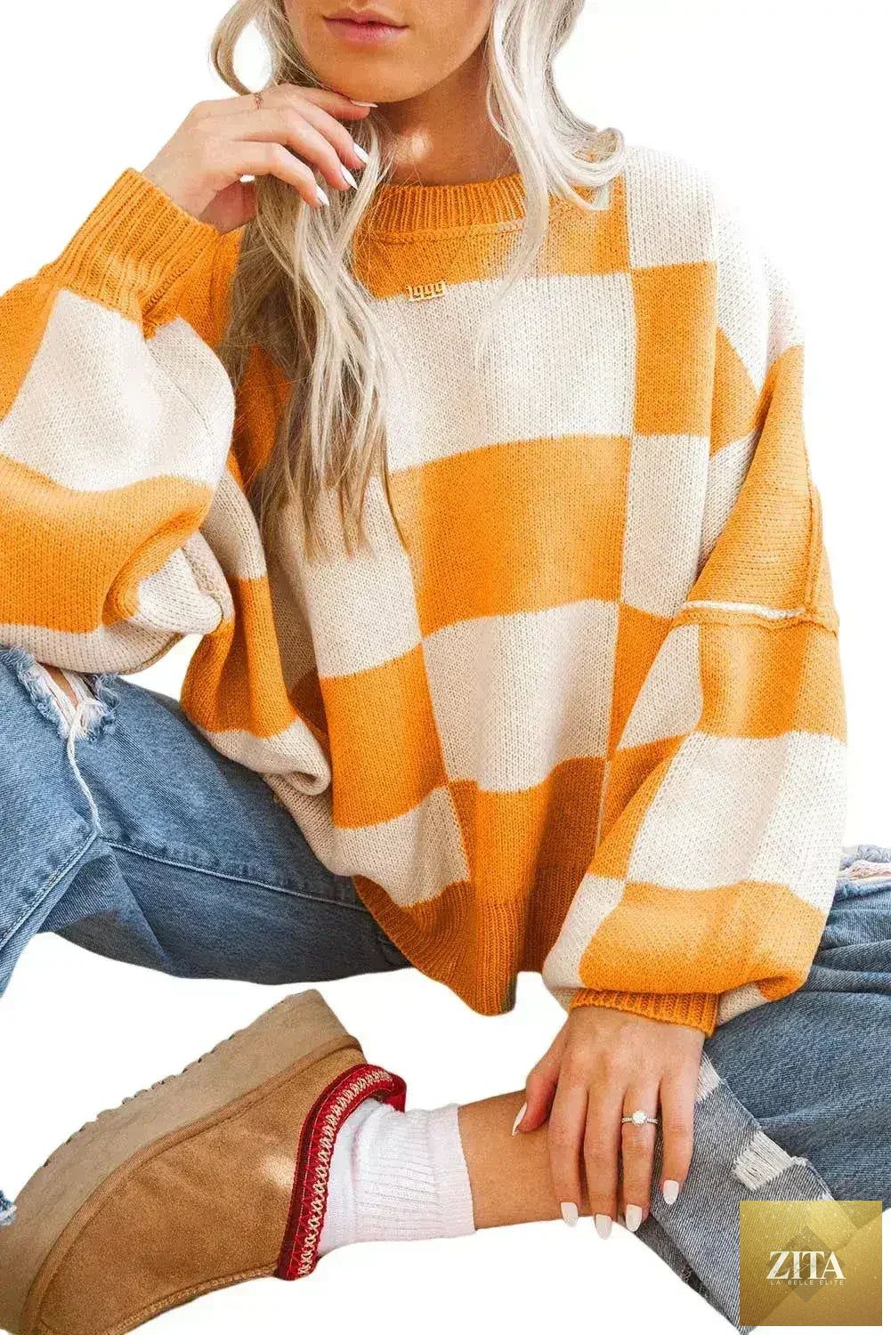 Orange checkered Femstylo sweater with bishop sleeves, featuring a cozy knit design perfect for stylish winter wear.