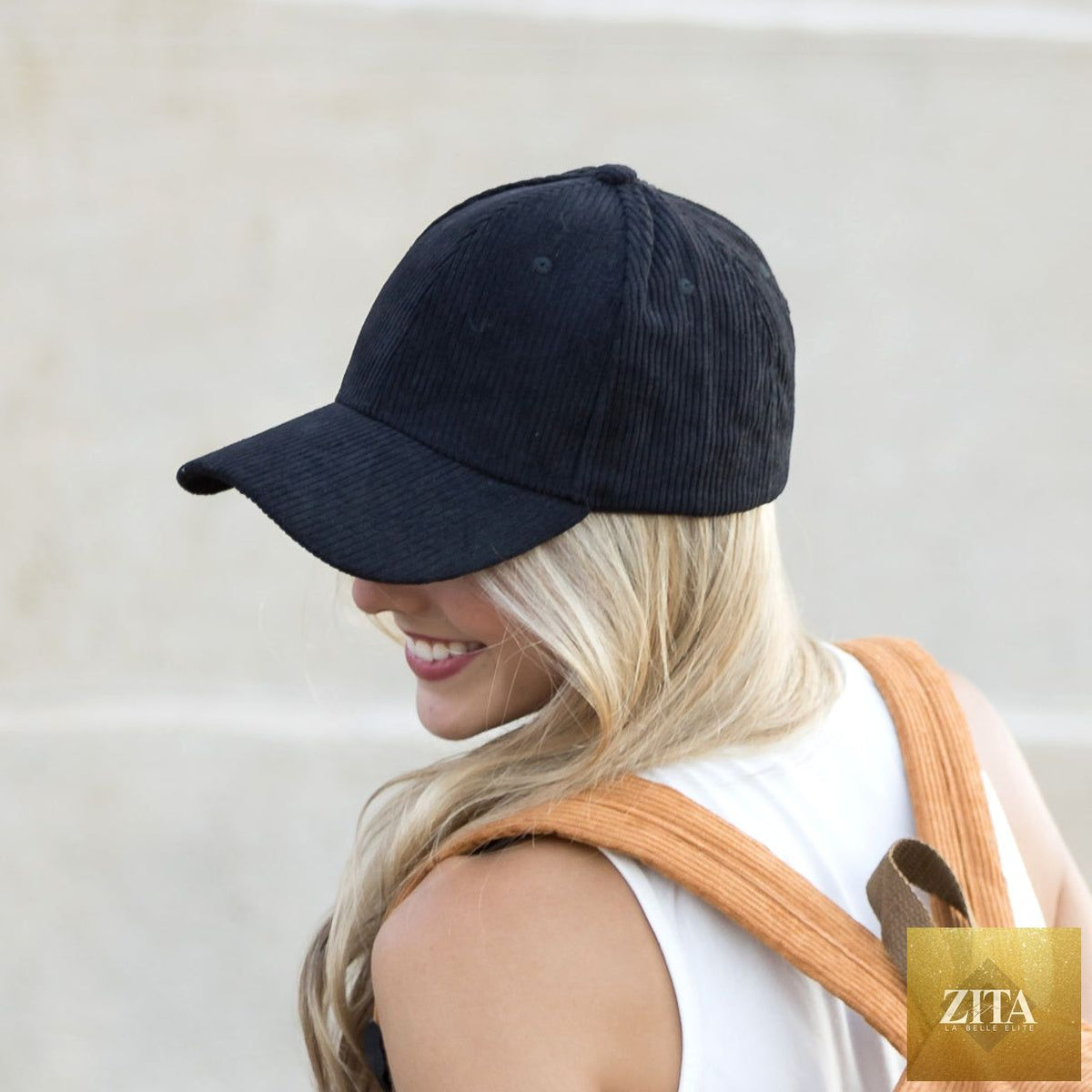 A woman wearing a beige corduroy boyfriend ball cap with a curved brim and relaxed fit, stylish casual accessory.
