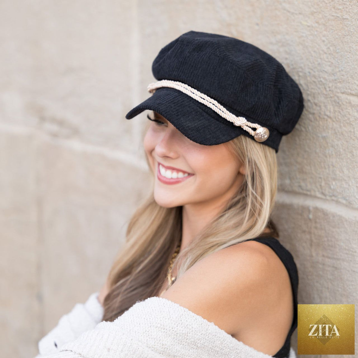 A woman wearing a tan corduroy newsboy cap by Aili's Corner, styled with casual clothing against a neutral background.