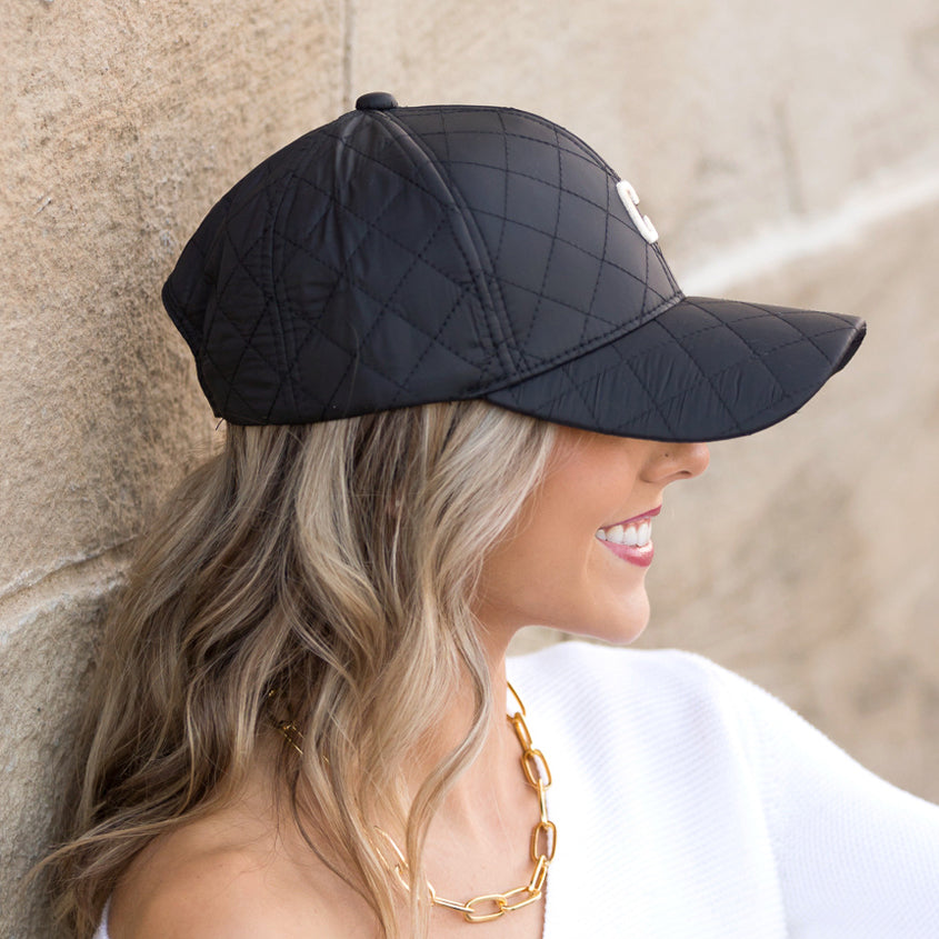 Aili's Corner quilted puffer baseball cap with a rounded brim and stitched quilted pattern, stylish and warm headwear.