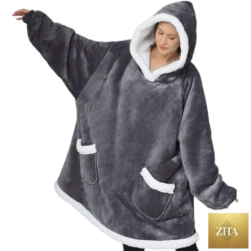 Mandotos winter TV hoodie blanket in cozy, oversized design with pockets, worn by woman lounging at home.