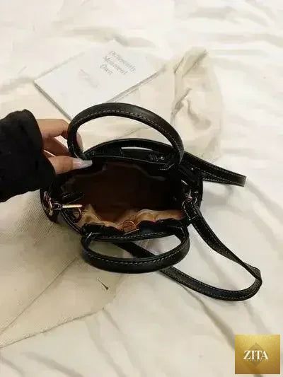 Femstylo stylish suede handbag with adjustable strap and dual-use design, showcasing its elegant exterior and versatile carry options.