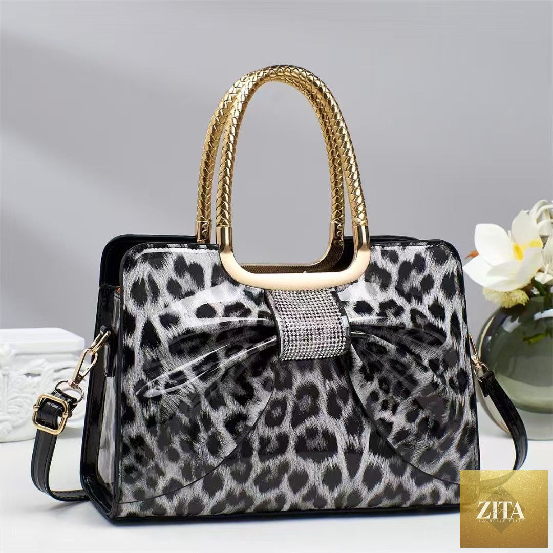 Elegant genuine leather handbag with leopard print and hot-stone embellishments, designed for versatile and fashionable women's style.