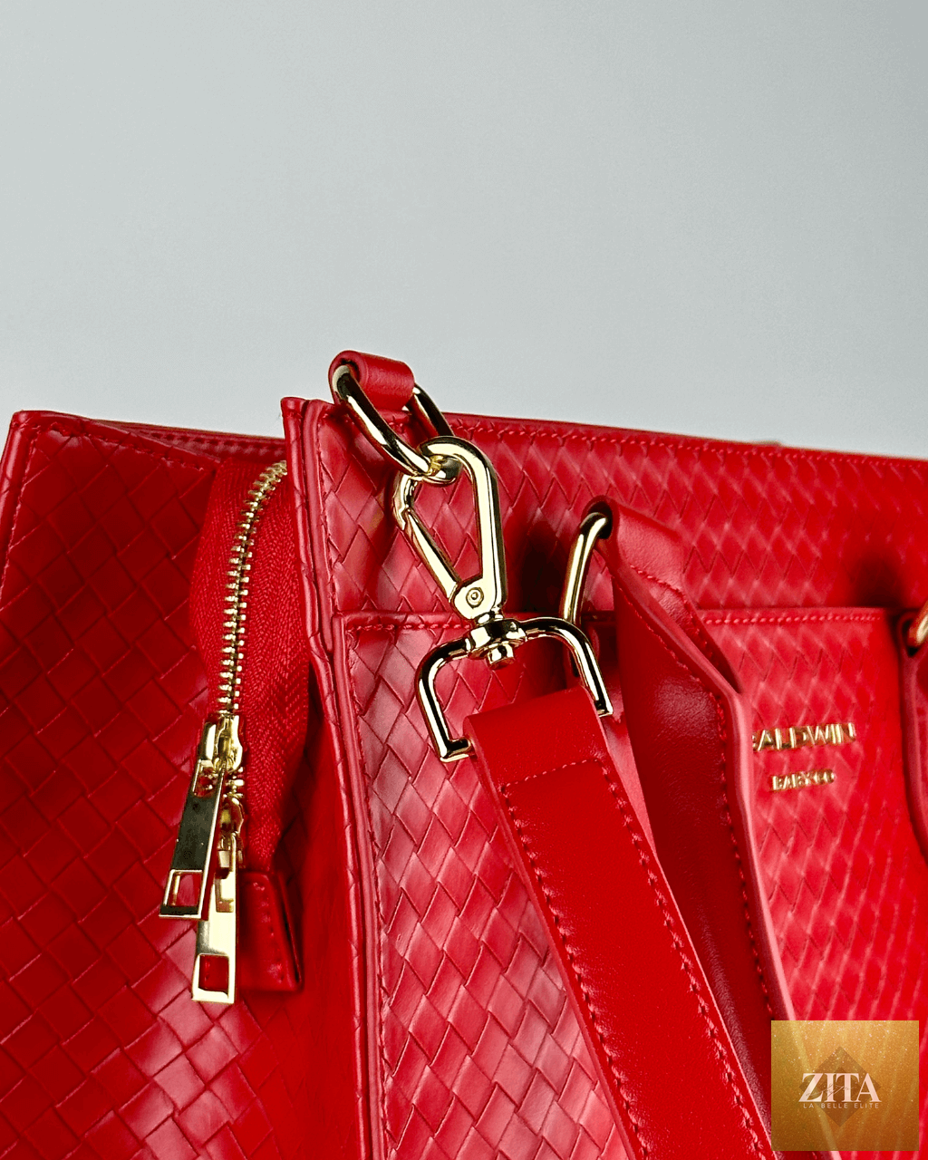 Baldwin Baby Company Montrose Diaper Bag Tote in vibrant cardinal red with hardware accents, showing its spacious design and sturdy handles.
