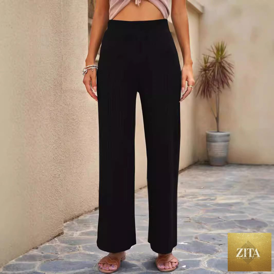 Women's high-waisted ribbed straight-leg pants in a neutral color, styled on a model, showcasing the fit and fabric texture.