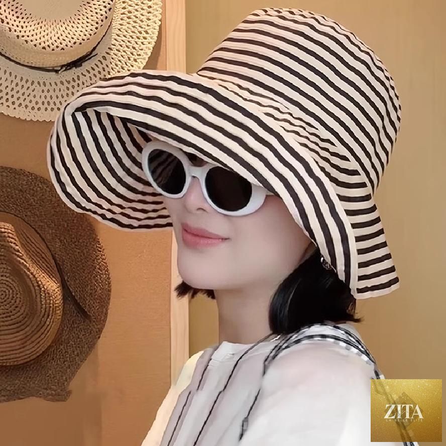Women's wide-brim striped sun hat by Zita La Belle Elite with UV protection and adjustable fit, shown in a natural outdoor setting.