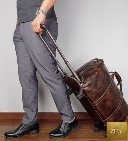 Large capacity cowhide trolley travel bag with sturdy wheels and leather handles, ideal for travel and storage.