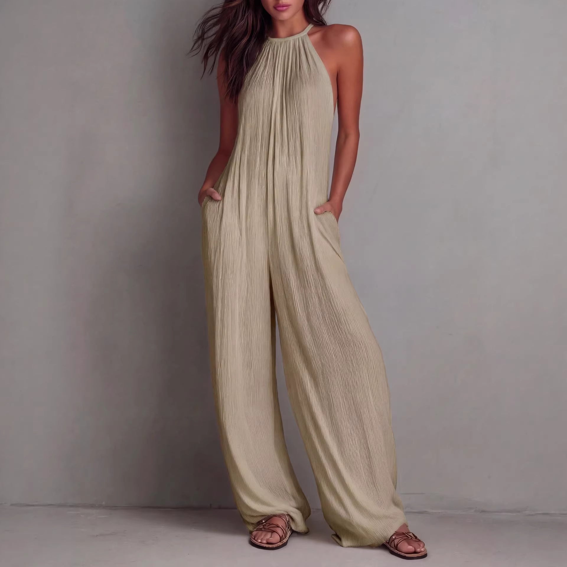 Women's sleeveless open-back wide-leg pleated jumpsuit by FitiqueFit, casualwear, featuring a stylish design and flowing fabric.