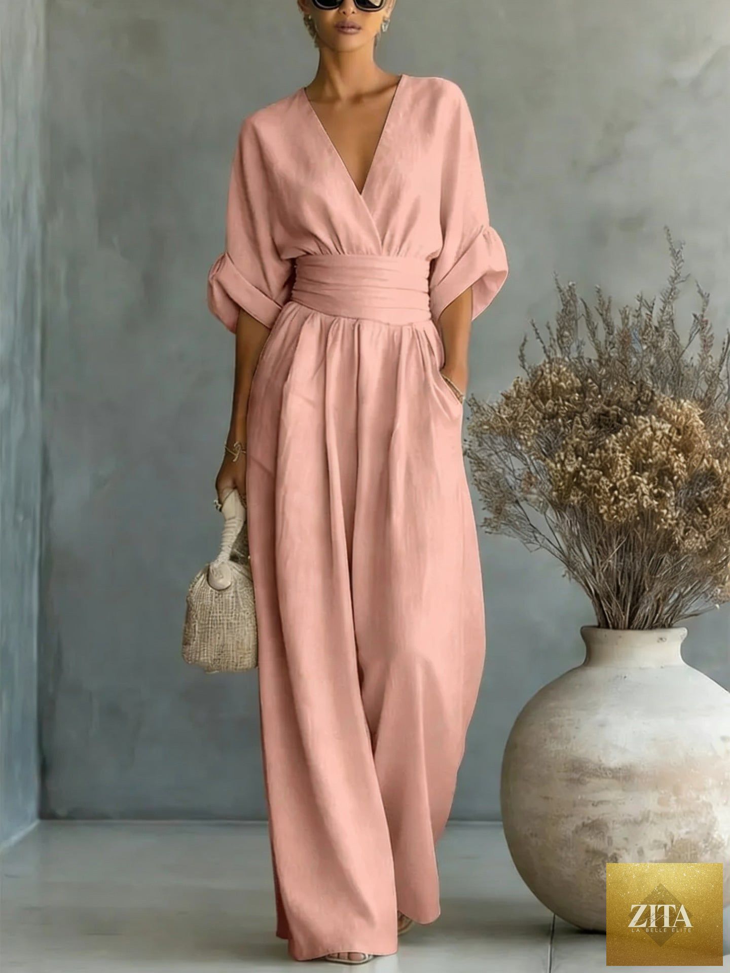 Women's MERIDGE v-neck wide-leg jumpsuit with high waist and pleated details, shown in a stylish and elegant fit.