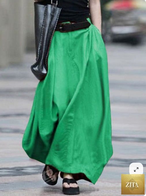 Women's high-waist flared maxi skirt in solid cotton linen with pockets, from FitiqueFit, showcasing its flowy silhouette and casual style.