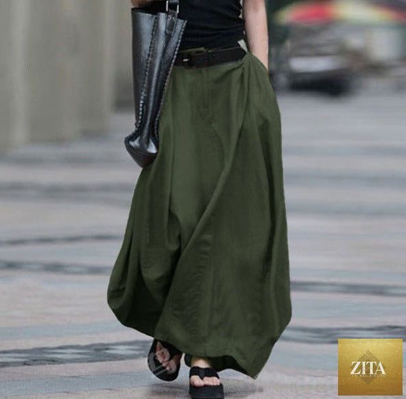 Women's high-waist flared maxi skirt by FitiqueFit in solid cotton linen with pockets, showcasing its flowing design and comfortable fit.