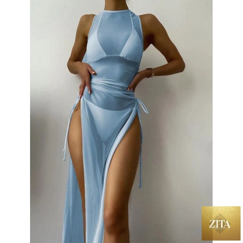 Women's solid color three-piece bikini set with matching maxi dress cover-up, swimwear by FitiqueFit on a model at the beach.