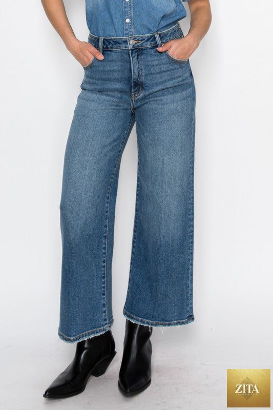 Light blue Artemis Vintage ultra high rise crop wide jeans displayed on a hanger, showcasing the relaxed fit and stylish cut.