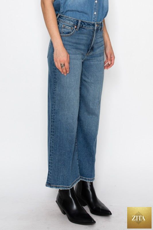 Light blue Artemis Vintage ultra high rise crop wide jeans displayed on a model with a casual pose.