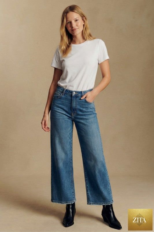 Light blue Artemis Vintage ultra high rise crop wide jeans displayed on a hanger showing their relaxed fit and distressed details.