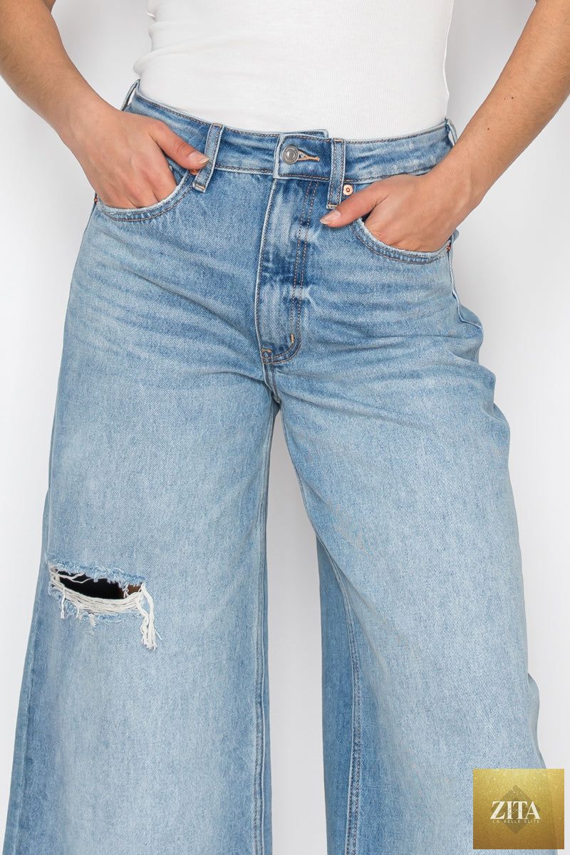 Artemis Vintage hybrid style ultra high rise relaxed jort jeans with distressed details and cuffed hems on a model.