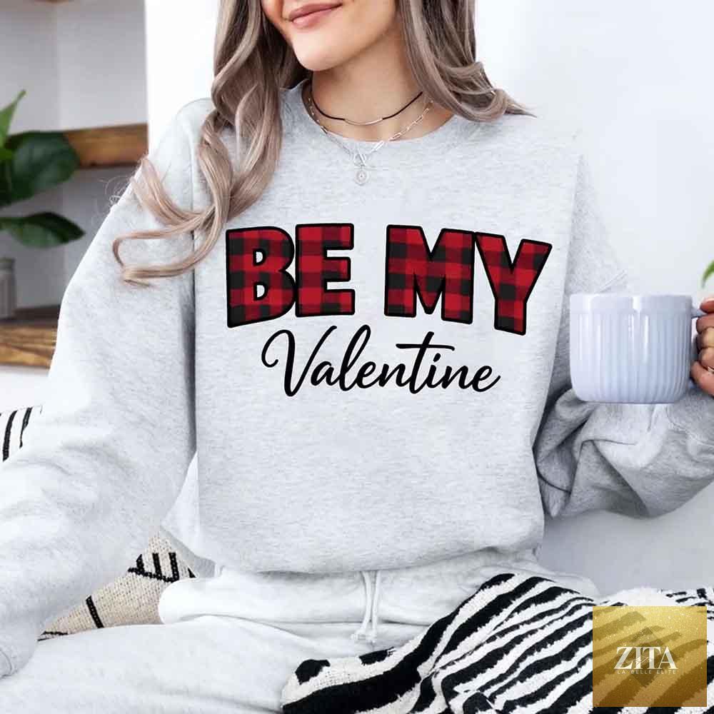 Red and black buffalo plaid crewneck sweatshirt with "Be My Valentine" text by Adorb Custom Tees, perfect for Valentine's Day.