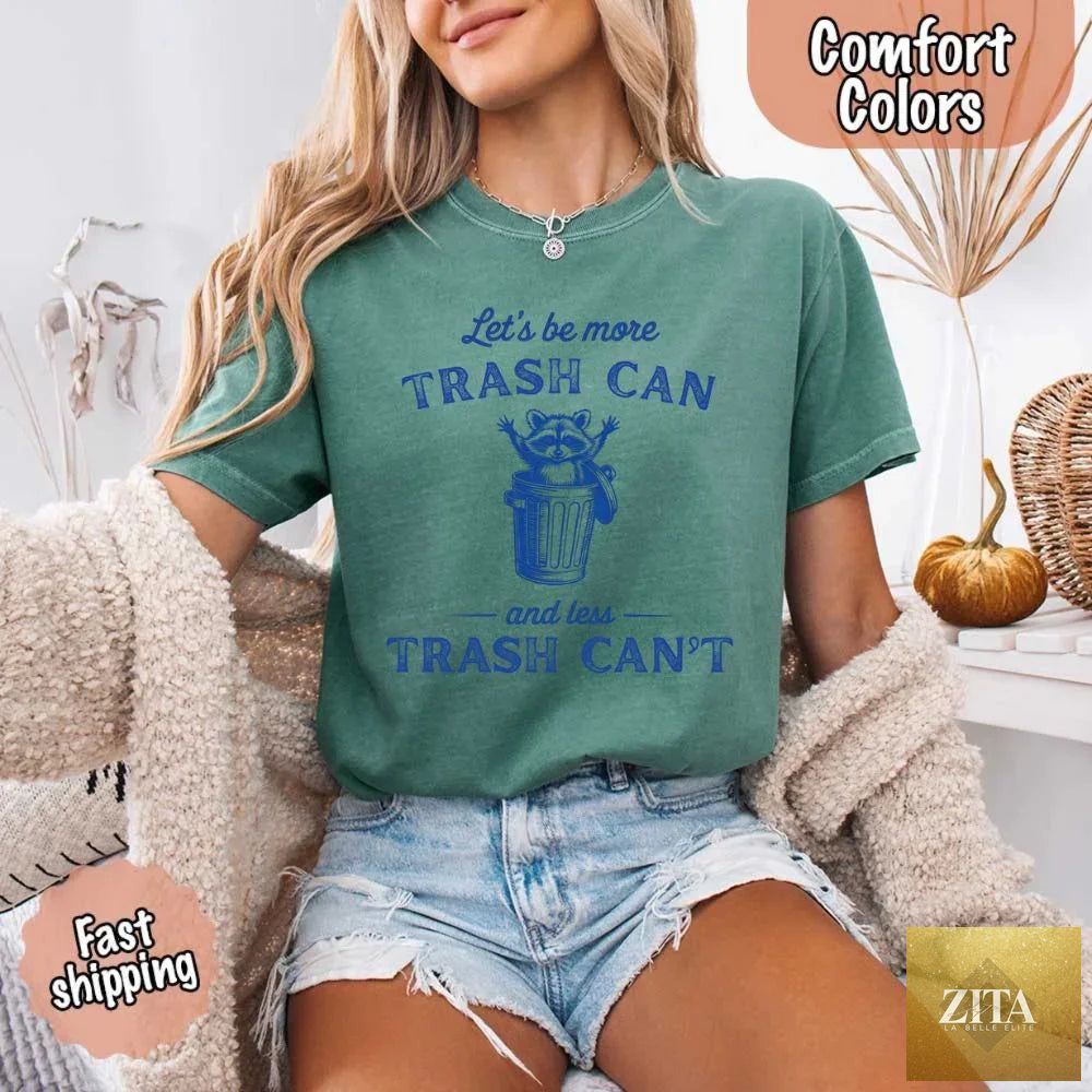 Comfort Colors funny T-shirt featuring a raccoon design with "Let's Be More Trash Can" slogan, by Adorb Custom Tees.