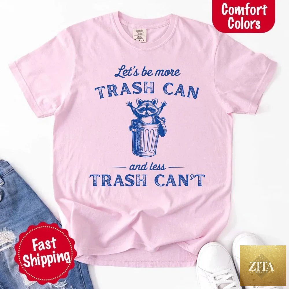 Comfort Colors funny T-shirt featuring raccoon design with the phrase "Let's Be More Trash Can" in bold print.