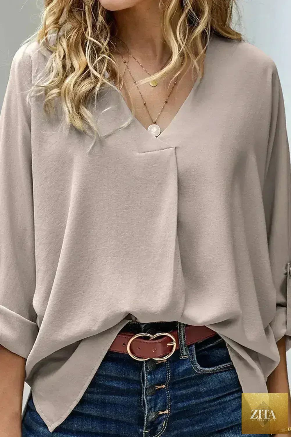 Elegant apricot V-neck blouse with 3/4 sleeves and high-low hem from Femstylo, showcased on a model.