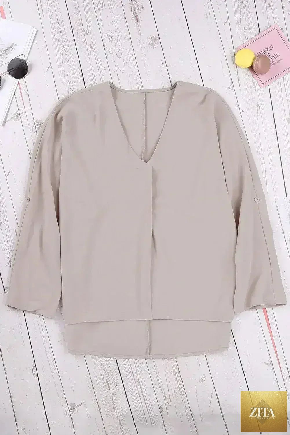 Elegant apricot V-neck blouse with 3/4 sleeves and high-low hem from Femstylo, displayed on a hanger.