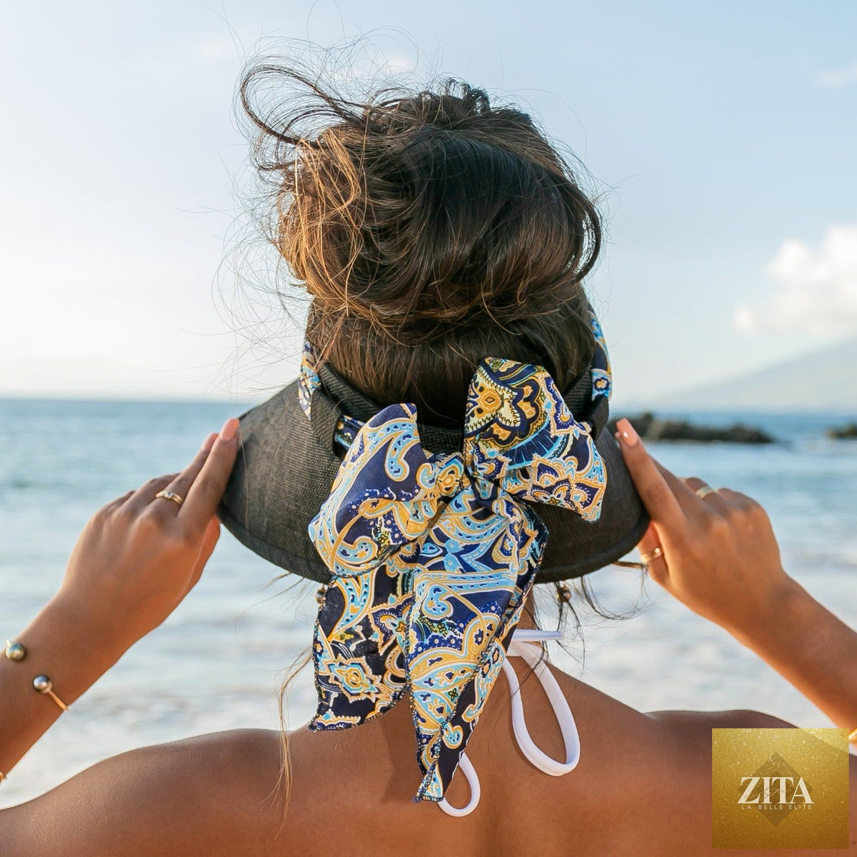 A woman wearing Aili's Corner sun visor with a stylish scarf accent, providing sun protection and fashionable accessory.