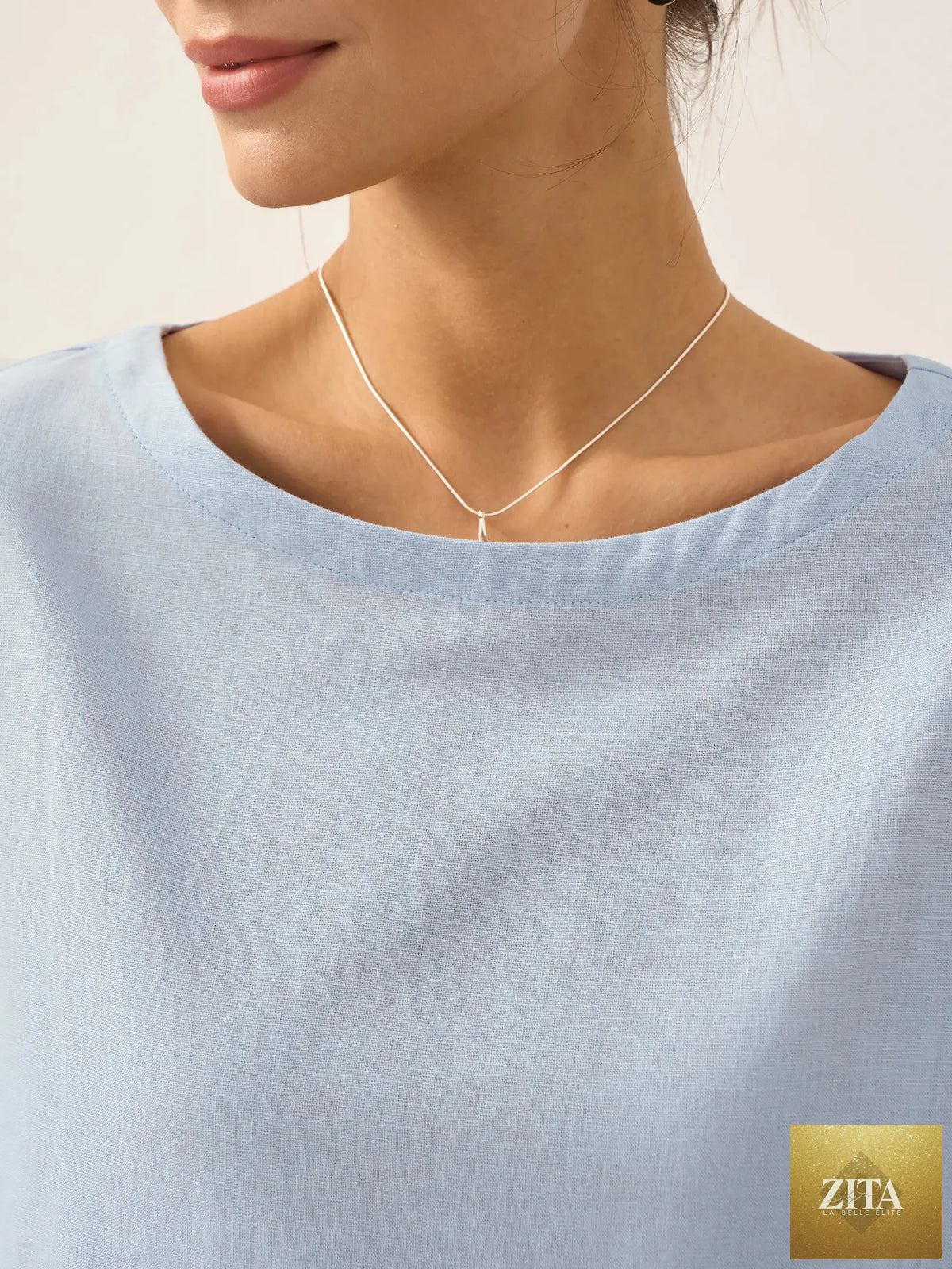 LINTICO Linen white boat neck oversized top with a relaxed fit, made from a linen blend fabric, shown on a model.