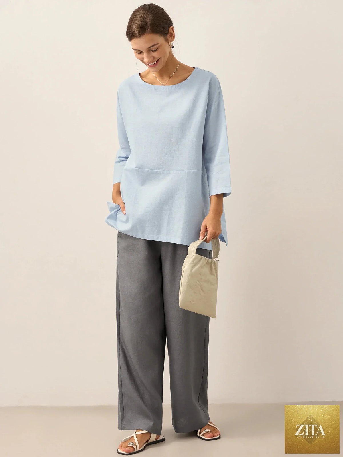 LINTICO linen white boat neck oversized top with a relaxed fit, made from linen blend fabric, shown on a hanger.