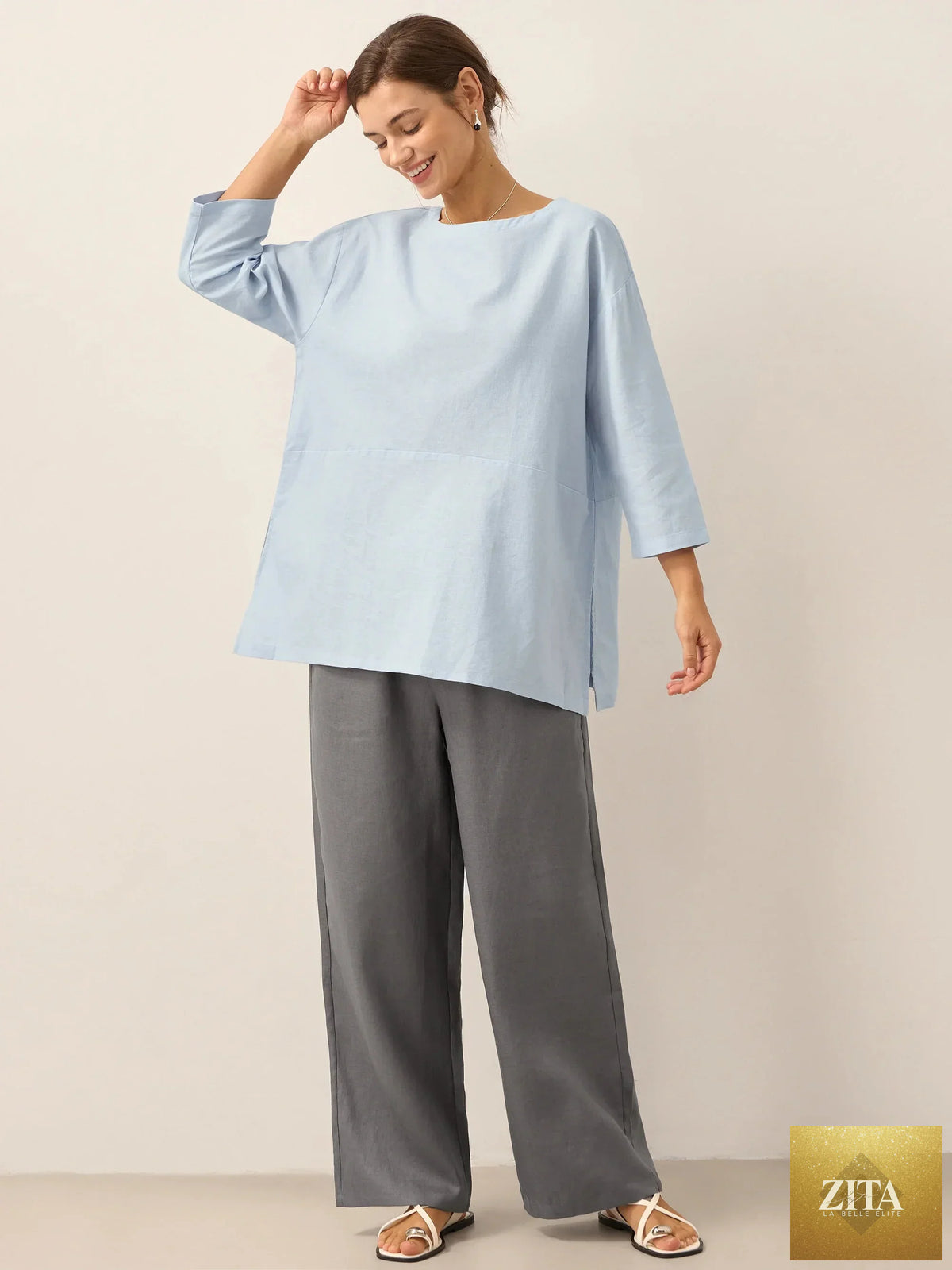 LINTICO linen white boat neck oversized top with a relaxed fit, made from linen blend fabric, displayed on a hanger.