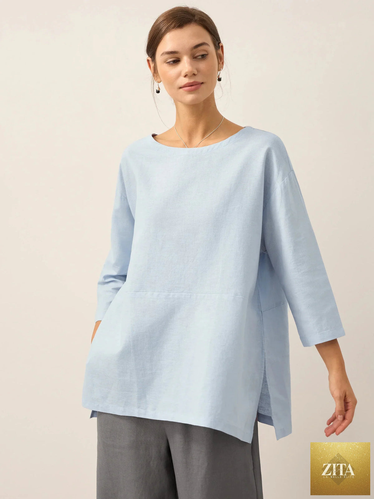 LINTICO white linen blend boat neck oversized top with long sleeves and relaxed fit, displayed on a hanger.