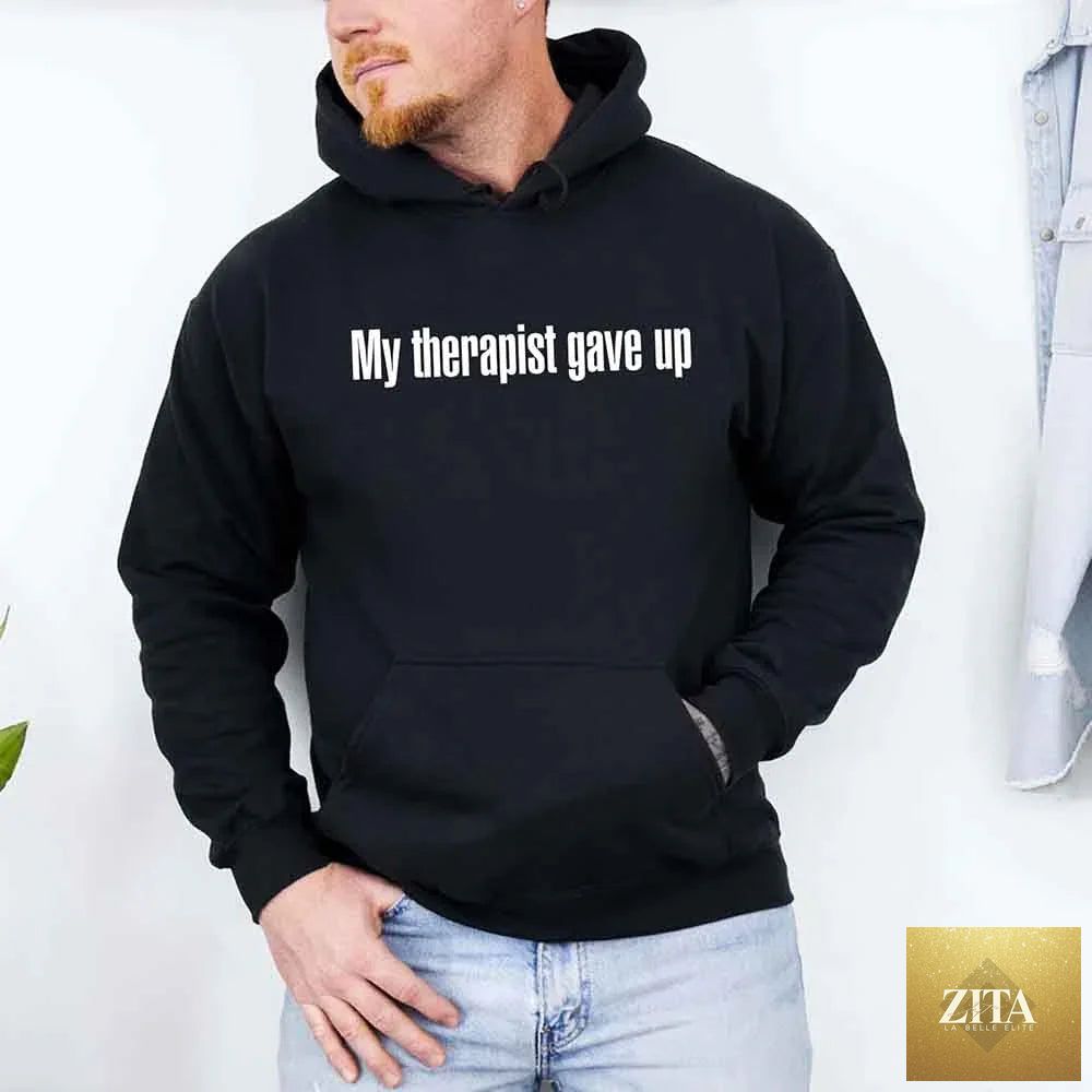 Black hoodie from Adorb Custom Tees with humorous "My Therapist Gave Up" slogan, casual style, and comfortable fit.