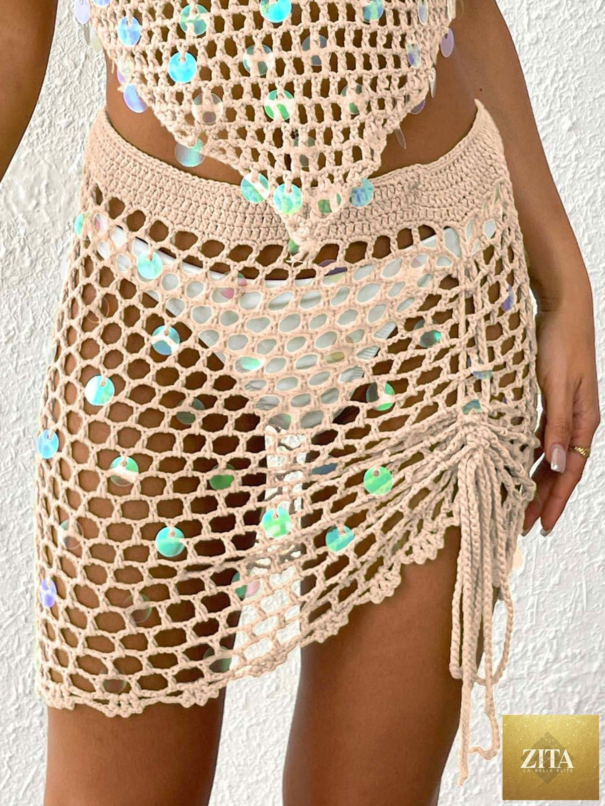 Women’s Bella Mia tight hollow out cutout crochet skirt with asymmetric design, sequin accents, and drawstring strap for beach vacation style.