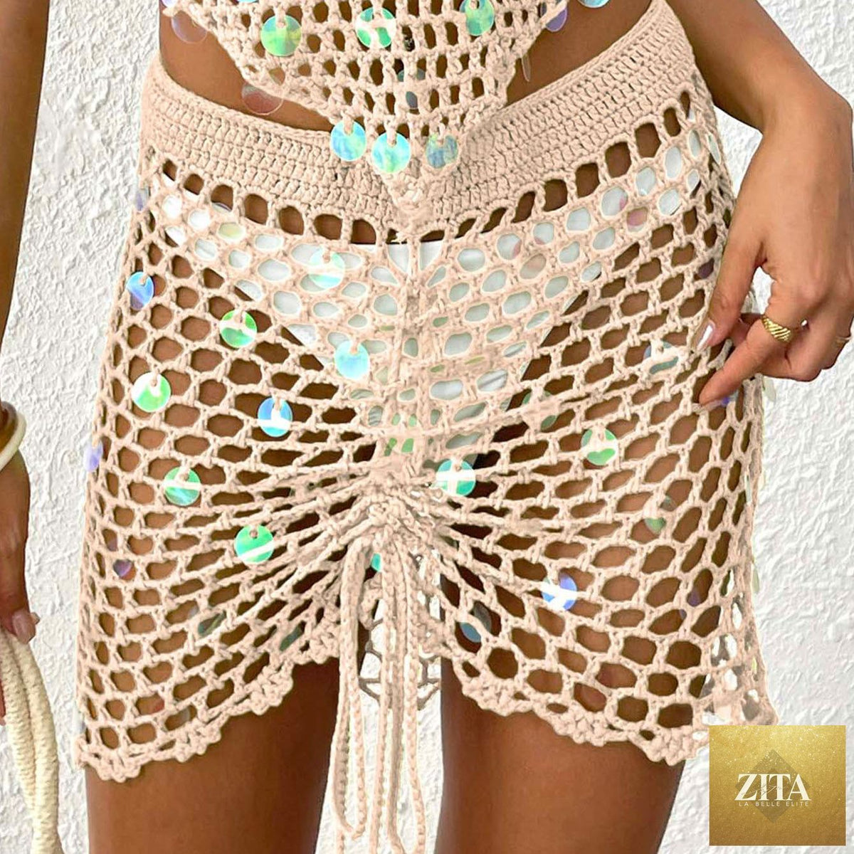 Bella Mia women's tight beach skirt with sequin stitching, crochet details, asymmetric design, drawstring straps, and hollow cutout.