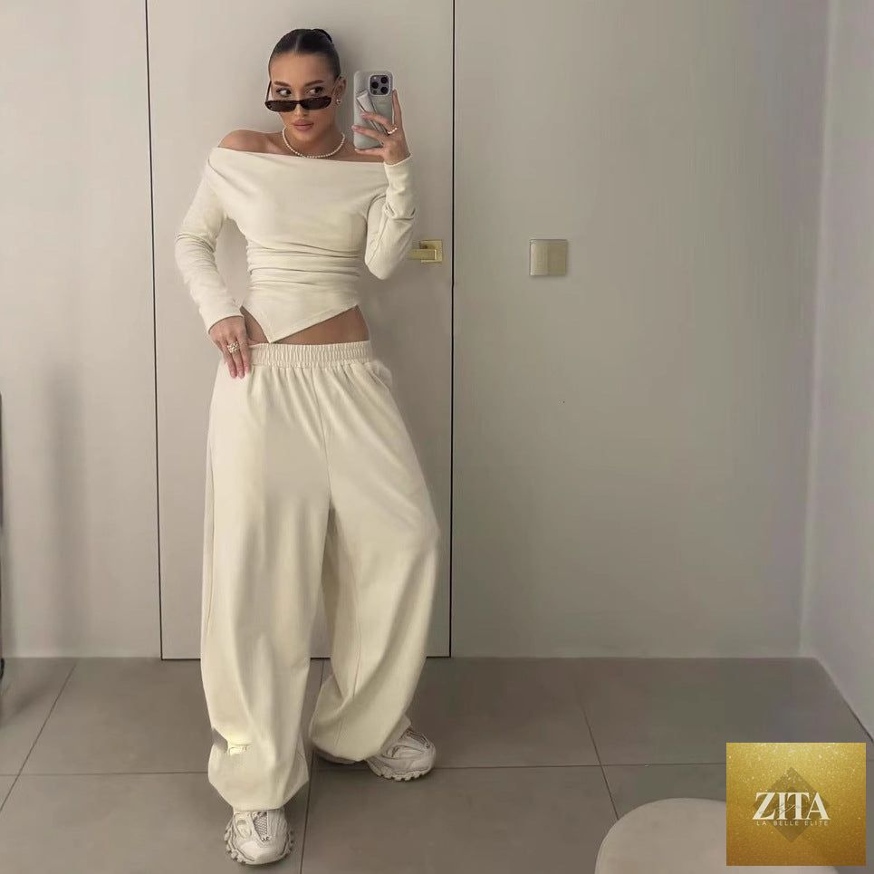 Asymmetric hem long T-shirt with fall-off neck paired with straight-leg trousers in casual two-piece set by Wanita Store.